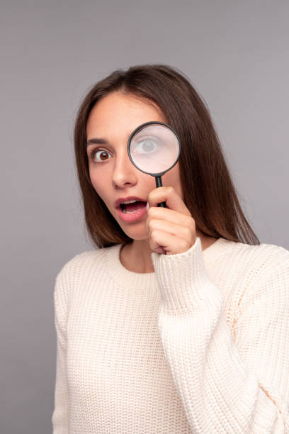 istock Surprised young woman with magnifier 1316301815