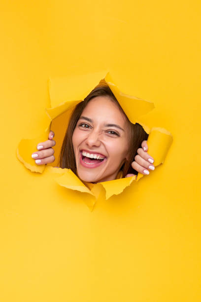 istock Excited woman looking through torn paper 1316301824
