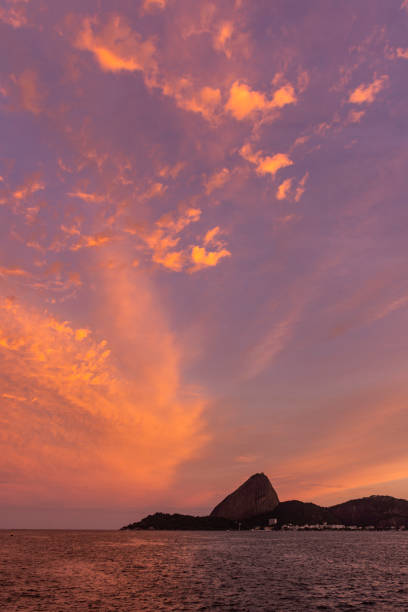 splendida vista del tramonto sulle nuvole arancioni su sugar loaf e oceano - urca rio de janeiro rainforest brazil foto e immagini stock