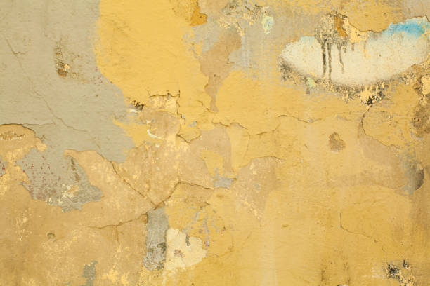 istock Old dirty yellow stucco plaster wall background. Painted grunge cement concrete wall texture 1316305189