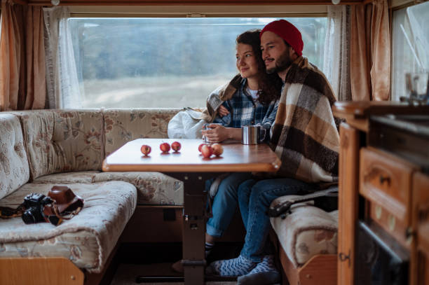 istock Couple sitting at a table in a motorhome and drinking tea. 1316306269