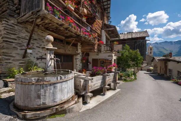 Saint-Veran village with wooden fountain in summer. Located in the Queyras Regional Natural Park, Hautes-Alpes, Alps, France