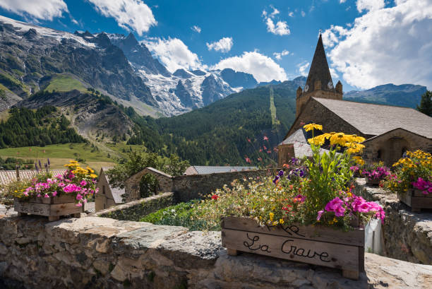 il villaggio di la grave e la sua chiesa nel parco nazionale degli ecrins con la vetta di la meije. estate nel massiccio degli oisans. alta alpi, alpi francesi, francia - provenza alpi foto e immagini stock