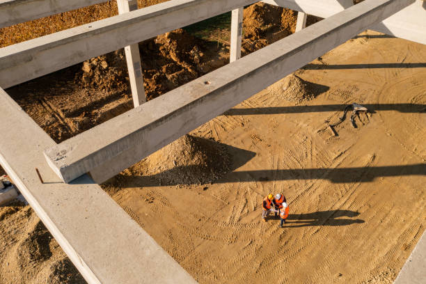 construction workers standing under frame structure - land development aerial view planning imagens e fotografias de stock