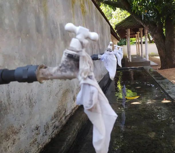 Photo of The plastic water taps shoot in rural religious area - Stock photo