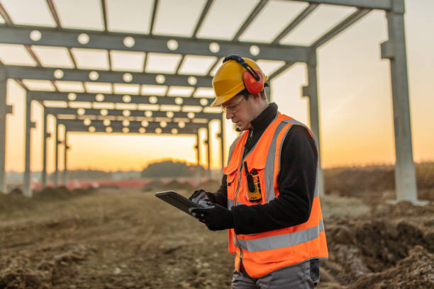 arquiteto usando tablet digital em canteiro de obras - architect construction engineer standing - fotografias e filmes do acervo