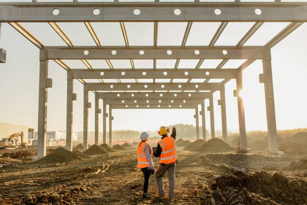 architekci omawiający prace na placu budowy - architect construction engineer standing zdjęcia i obrazy z banku zdjęć