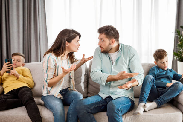 A modern children portrait - boys on their phones, while none is paying attention to their parents arguing Modern children portrait - boys on their phones, while none is paying attention to their parents arguing arguing couple divorce family stock pictures, royalty-free photos & images