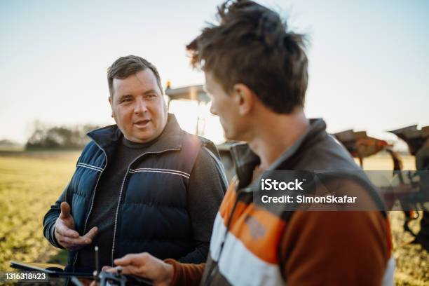 Teamwork On Agricultural Field Stock Photo - Download Image Now - Farmer, Discussion, Talking