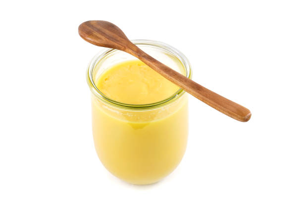 Homemade purified butter,  ghee ( Sade yag ) in jar and wooden spoon .  Ghee is purified butter . Isolated on White background. ghee stock pictures, royalty-free photos & images