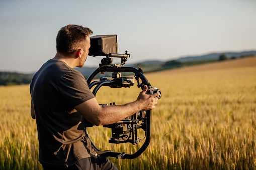 Cameraman filming on wheat field