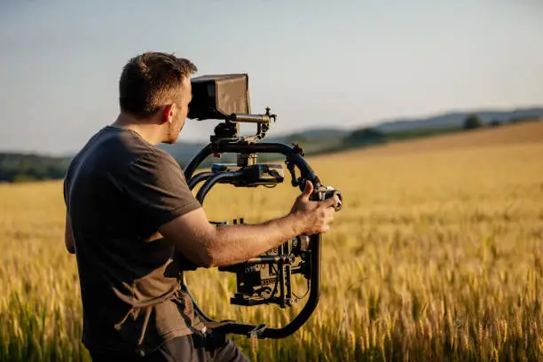 Cameraman filming on wheat field