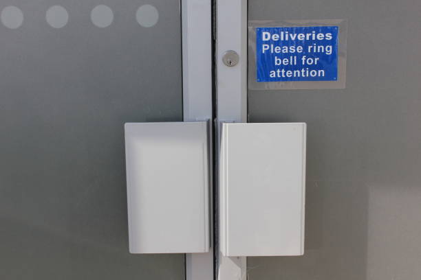 Deliveries Please ring bell for Attention Glazed Double doors with pull handles and frosted glass, a lock and a little directional sign frosted glass door office stock pictures, royalty-free photos & images