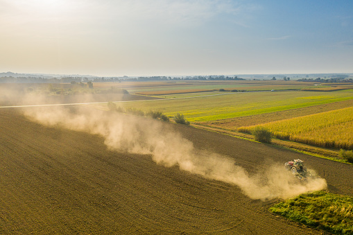Aerial view of tractor working on ploughed field