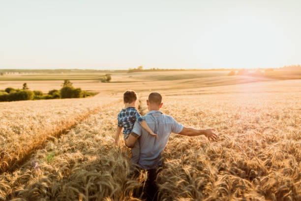istock Father and son walking on agricultural field 1316322611