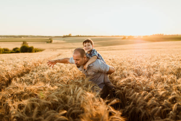 istock Father giving his son piggyback ride on field 1316322643