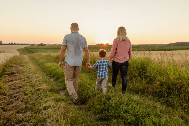 istock Parents holding hands of son while walking on field 1316322702