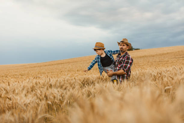 istock Boy with father touching wheat crops 1316322799