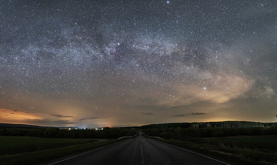 Suburban night highway, over the starry sky and the milky way