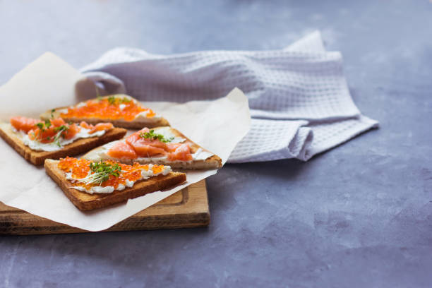sanduíches ou tapas de pão caviar vermelho e peixe vermelho - plank bread caviar close up - fotografias e filmes do acervo