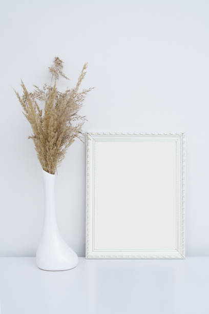 istock White photo frame mockup in white interior with vase and pampas grass 1316332922