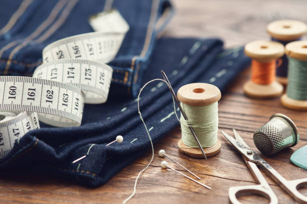 istock Shortening jeans. Measuring tape, scissors, spools of thread, thimble, including pins and chalk. Jeans cutting. 1316333117