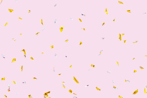 Golden silver sparkling confetti isolated on pink. Holiday effect