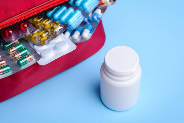 istock White plastic bottle near red bag with pills and capsules on a white background 1316334073