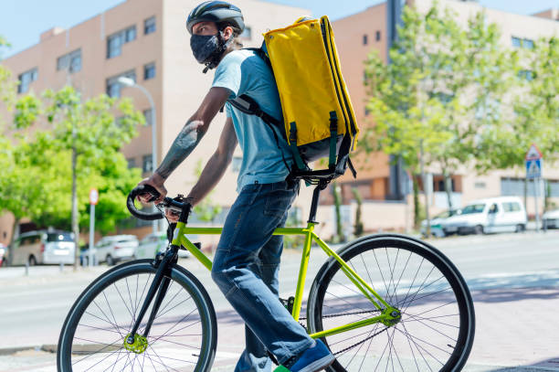 istock Delivery man on bicycle with mask 1316340917