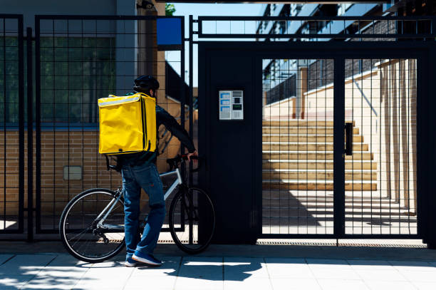 istock Delivery man on bicycle arriving home 1316340957