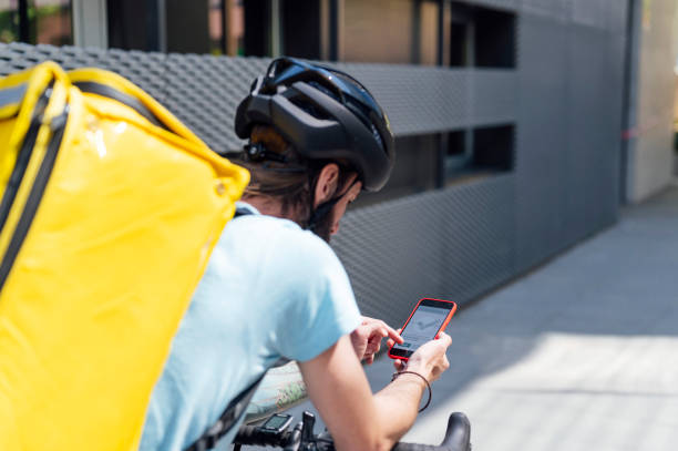 istock Delivery man on bicycle with mobile phone 1316340960