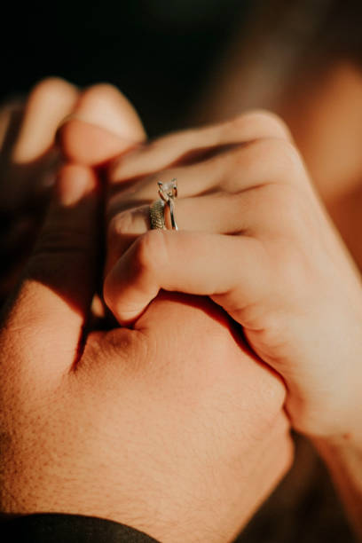 feche acima de um elegante anel de diamante de noivado no dedo feminino. conceito de amor e casamento. - wedding ring love engagement - fotografias e filmes do acervo