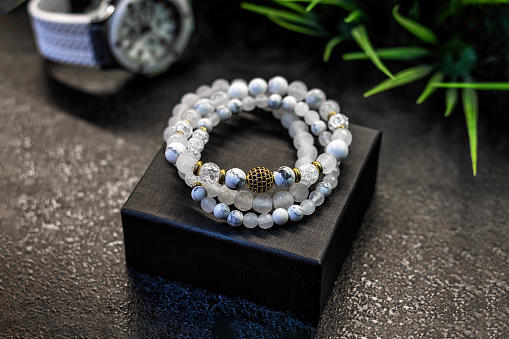 Accessories white bracelets made of precious stones and pearls, and gift wrapping. Close-up