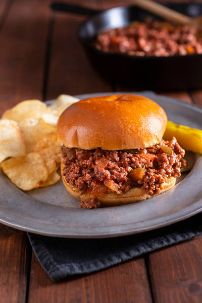 Sloppy Joe Sandwich Sloppy Joe Sandwich on a plate with Potato Chips and a Pickle. sloppy joes stock pictures, royalty-free photos & images