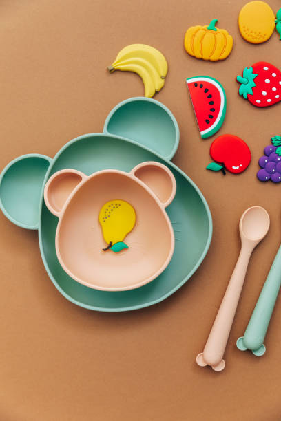 istock Bright silicone dishware on light background. Serving baby, first feeding concept. Flat lay, copy space, top view 1316344536
