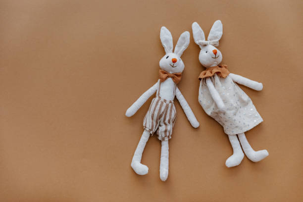 istock Two rabbits toys on brown background. Top view, flat lay 1316344544