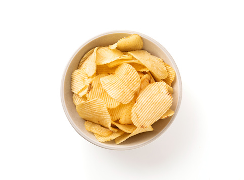 Bowl of crispy wavy potato chips or crisps with chili pepper flavor isolated on white background, top view