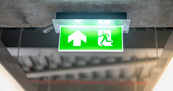 Emergency fire exit sign show the way to escape at the public area, warehouse store, For the security first about the being fire concept.\