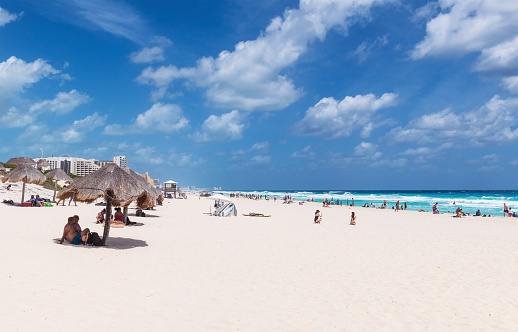 People sunbathing on Dolphin Beach by the Caribbean Sea, Cancun, Mexico.