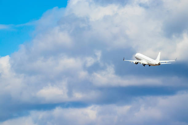 istock An airplane taking off toward white clouds in the sky 1316366404