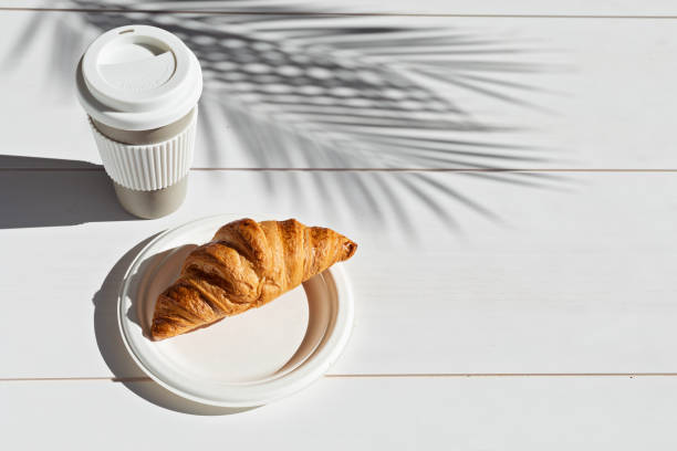 istock Hot coffee on the go and croissants for breakfast. Biodegradable, reusable takeaway cup 1316370123