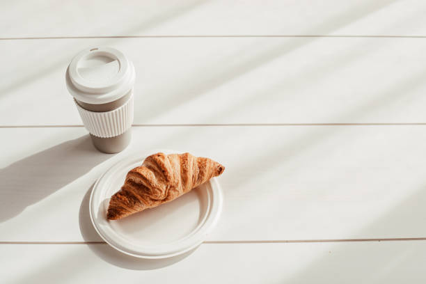 istock Hot coffee on the go and croissants for breakfast. Biodegradable, reusable takeaway cup 1316370156