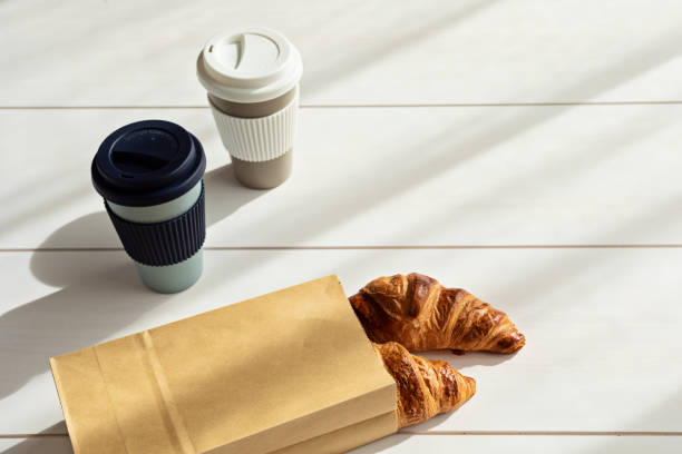 istock Hot coffee on the go and croissants for breakfast. Biodegradable, reusable takeaway cup 1316370175