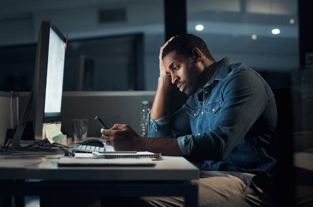 istock Shot of a young businessman looking stressed while using a smartphone during a late night in a modern office 1316371582