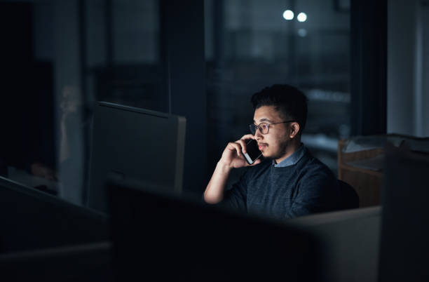 istock Shot of a young businessman using a computer and smartphone during a late night in a modern office 1316372244