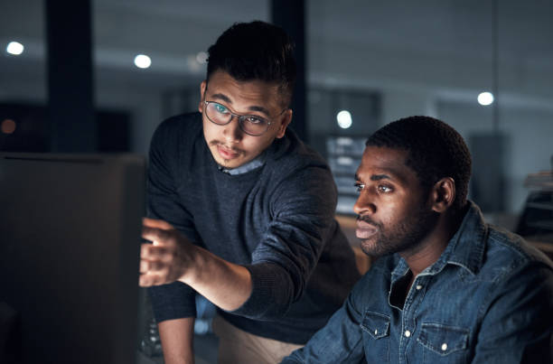 istock Shot of two young businessmen using a computer during a late night in a modern office 1316372250