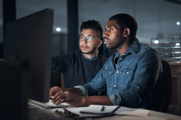 istock Shot of two young businessmen using a computer during a late night in a modern office 1316372257