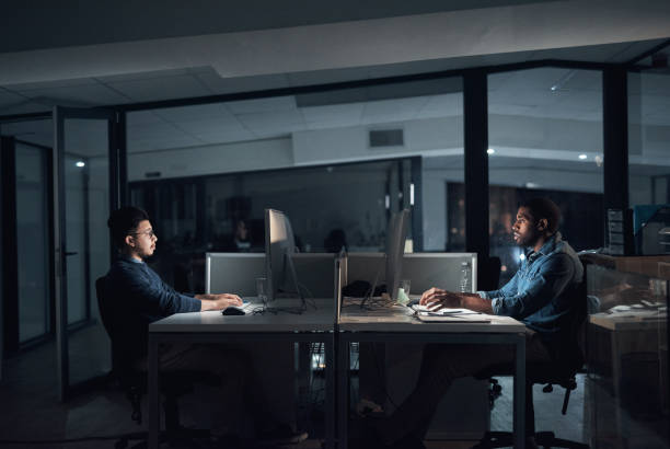 istock Shot of young businessmen using their computers during a late night in a modern office 1316372263