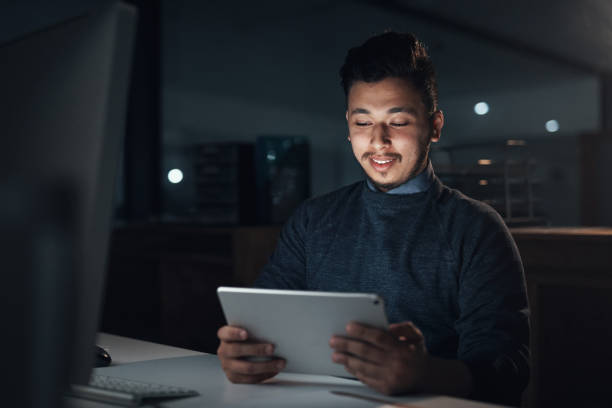 istock Shot of a young businessman using a digital tablet and computer during a late night in a modern office 1316372279