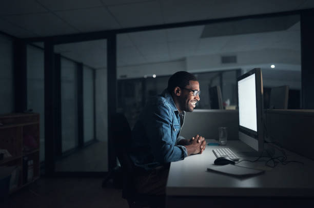 istock Shot of a young businessman using a computer during a late night in a modern office 1316372302